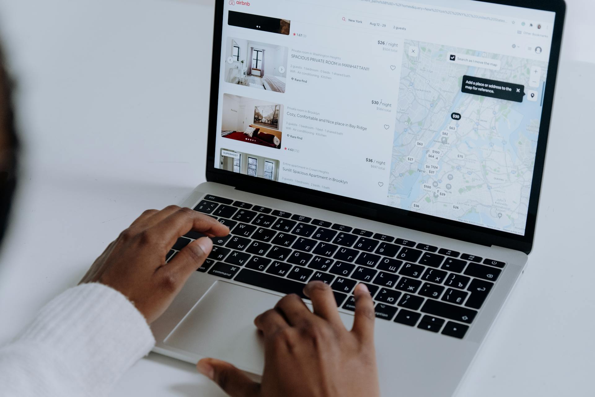 Persona revisando listados de Airbnb en laptop, ejemplo de renta vacacional Punta Cana comparada con alquiler largo plazo
